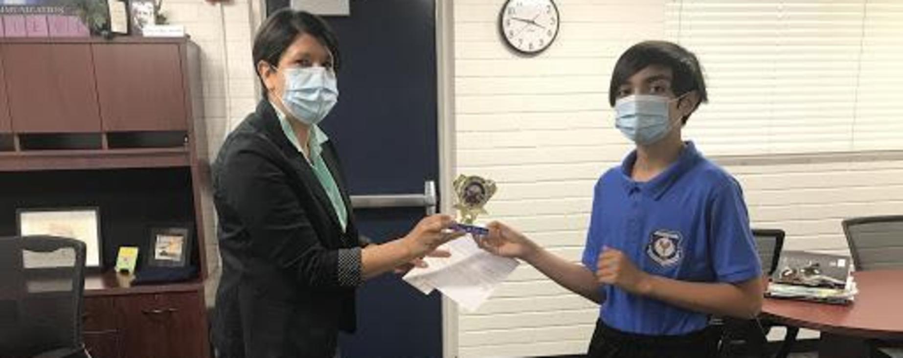 Principal handing trophy to student