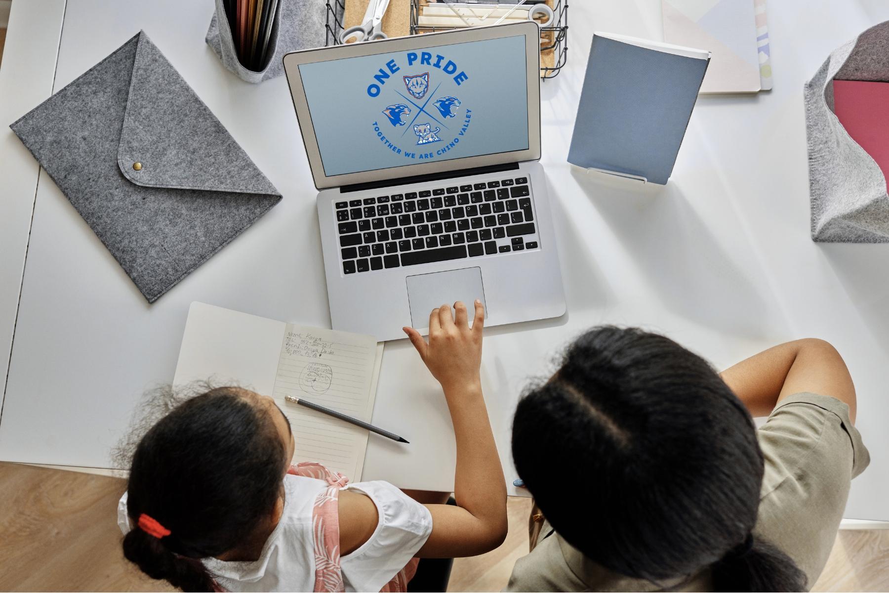 parent and student doing homework on laptop