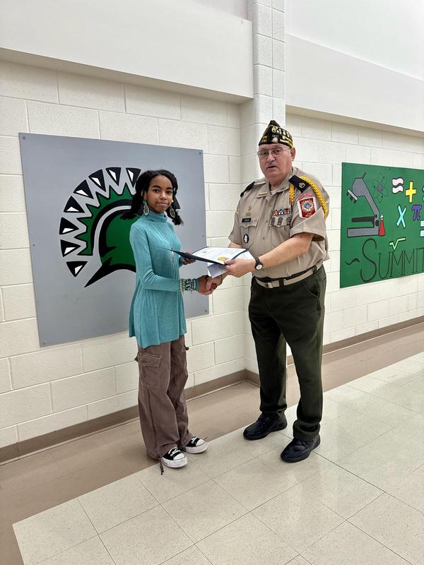 Summit Hill Junior High seventh grader Chloe Stanford is presented with a certificate, medal, and check by Robert Jensen from the Tinley Park VFW for writing the Best Seventh Grade Essay in the Tinley Park VFW’s Patriot’s Pen Youth Essay Contest and advancing to the district level.