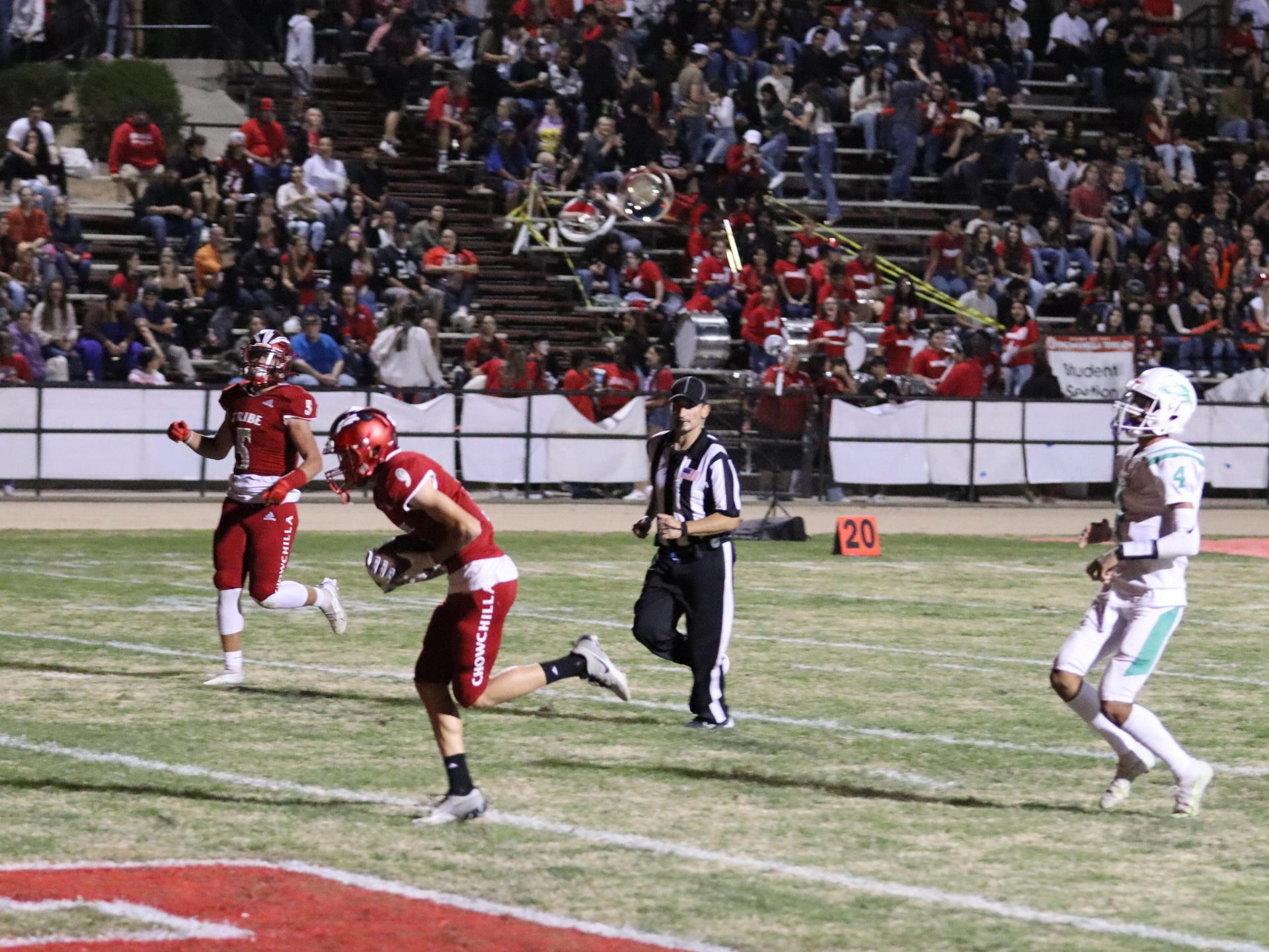 varsity football players in action against Riverdale
