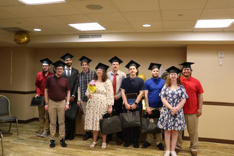 graduates standing together with graduation caps on