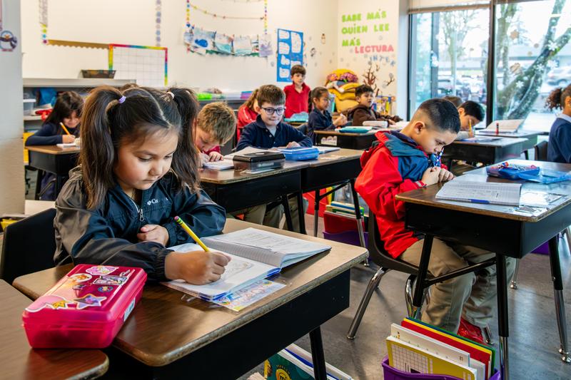 Arco Iris students work on assignments at their desks in their classroom.