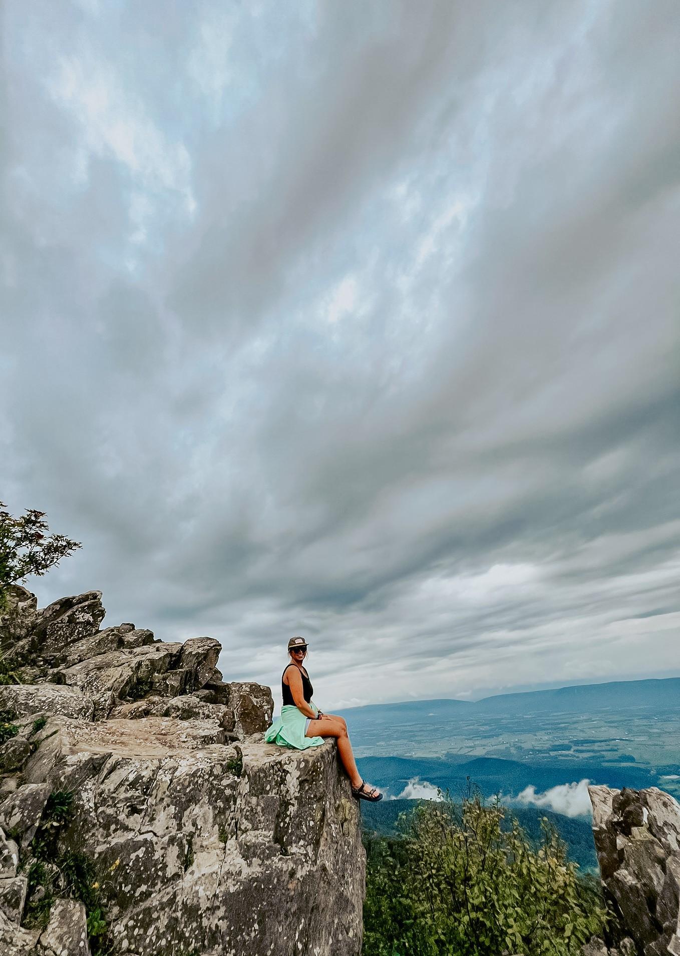 Mrs. Harris sitting on mountain cliff.