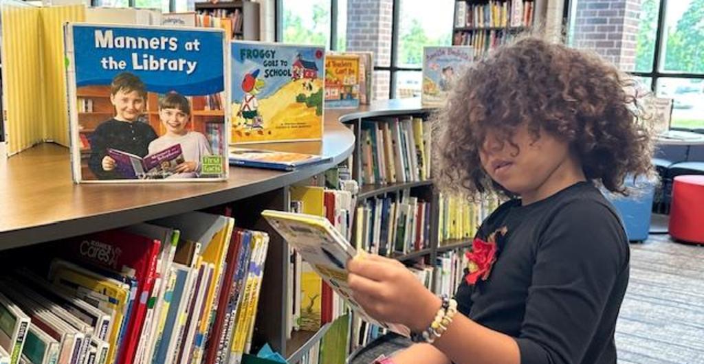 Student looking for a book in media center