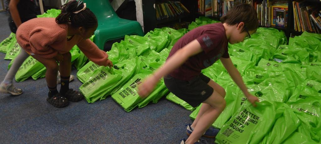 2 students choose a bag filled with books