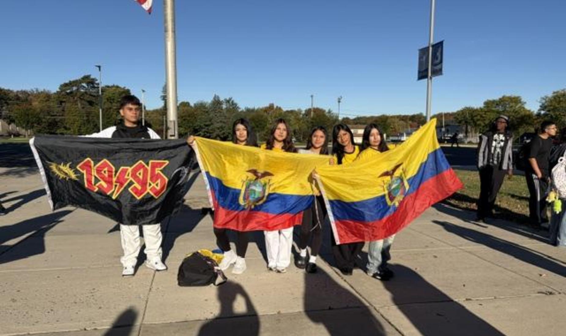 Group of people holding Ecuadorian flags and a black flag with '1995' written on it.