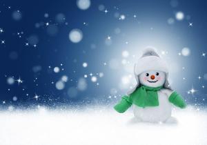 Photo of a snowman with a green scarf in the snow