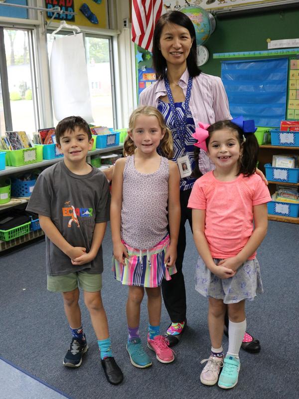 Photo of Jefferson principal Dr. Susie Hung with three students, all wearing mismatched clothing to illustrate how we respect differences.
