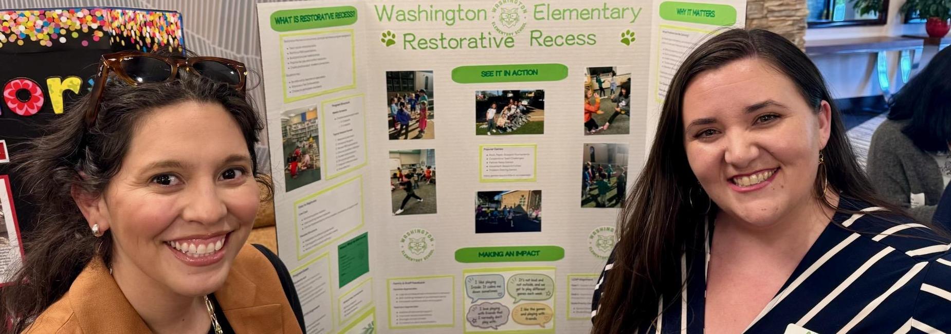 Ms. Granillo and Ms. Jaramillo smile in front of a presentation board featuring information about Washington's Restorative Recess.