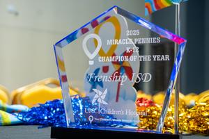 Close up photo of the acrylic award that says "Frenship ISD 2025 CMN K-12 Champion Award"