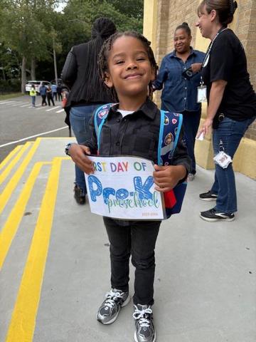 Students holds a first day of preK sign