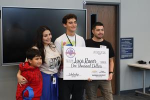 Luca and his family pose for a picture with his scholarship check
