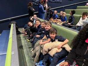 The first grade boys watch a puppetry performance.