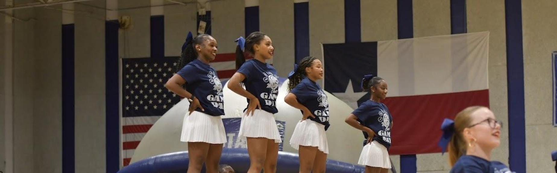 Cheerleaders performing with enthusiasm during an event.