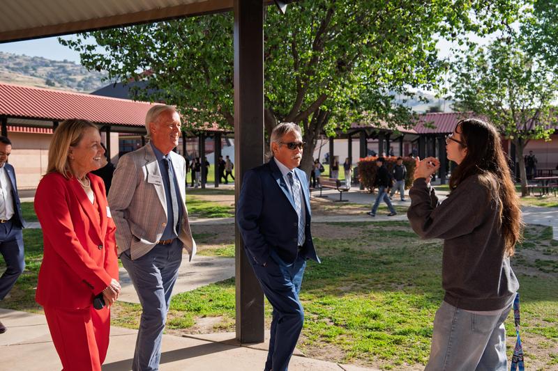 A student speaks with visiting district leaders on a school campus during the CSBA regional tour.