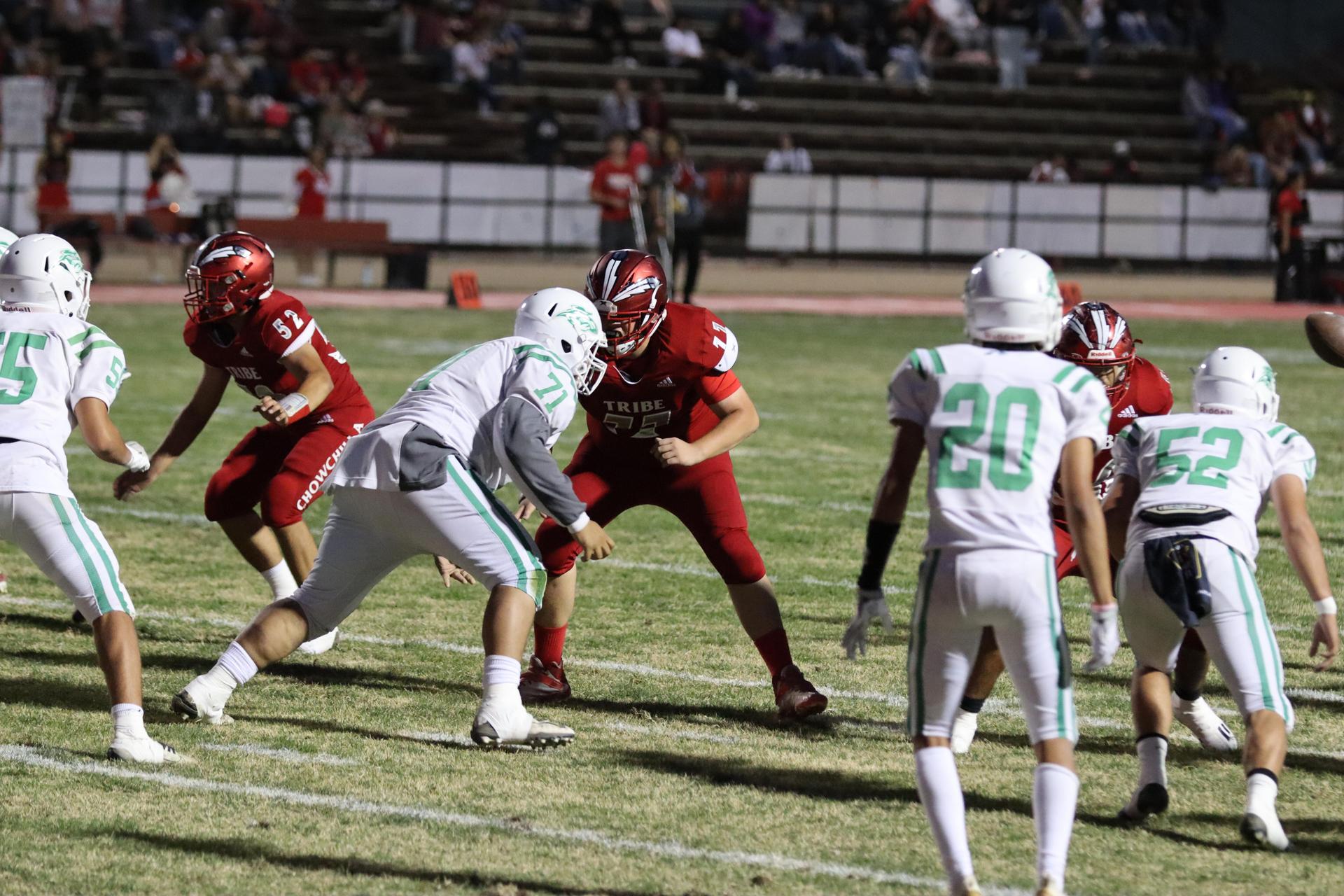 varsity football players in action against Riverdale