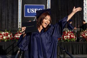 A female student from United Sierra Education Center shows off her diploma.