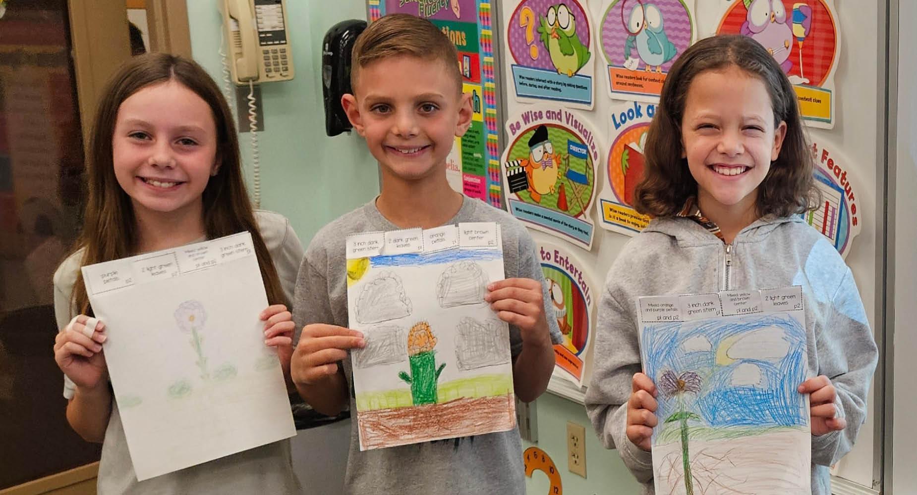 Harrison Park students from Mr. Leydig's classroom hold up their 'plant inherited traits' drawings.