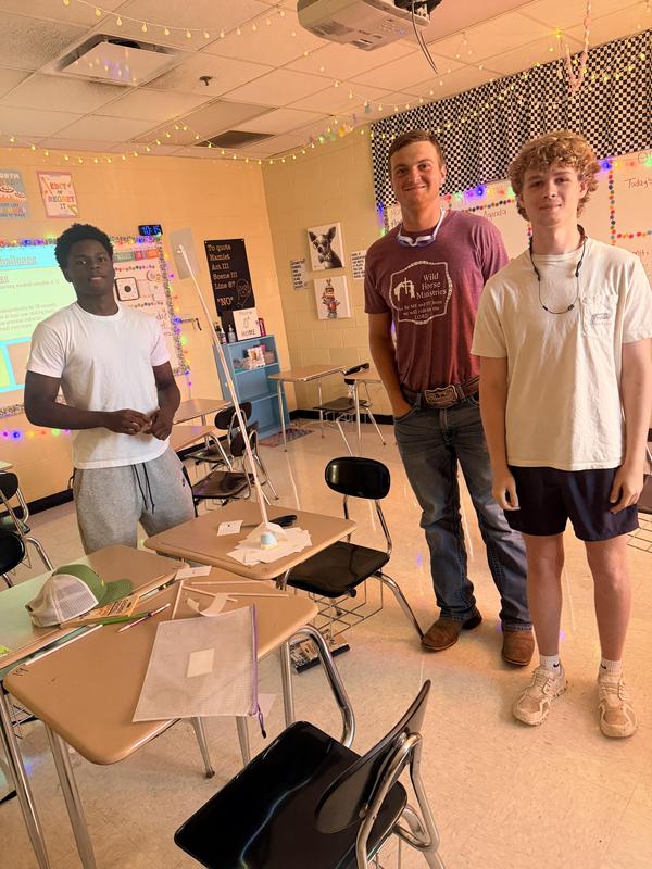students stand beside their finished project