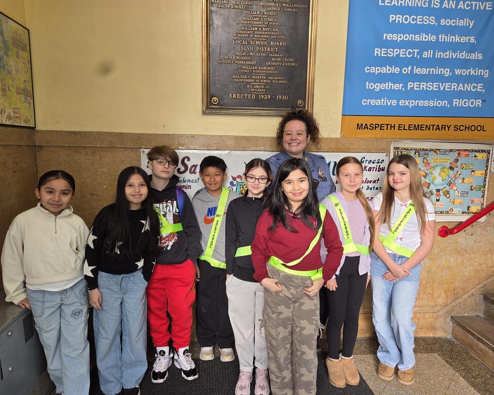 A group of students from the safety patrol team pose with the school security guard.