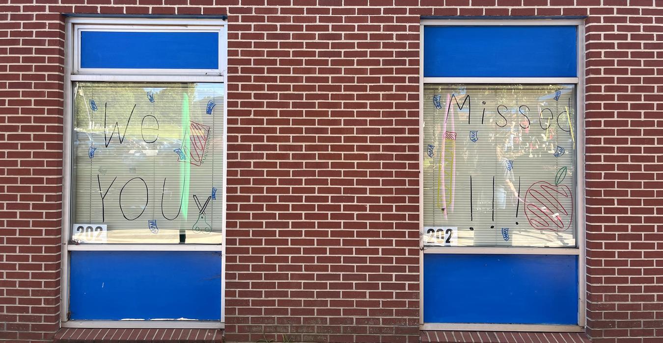 Windows with signs saying 'We Missed You' and colorful decorations.
