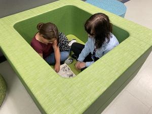 Current FHS mentor and elementary mentee reading together in alternatve seating pallet.