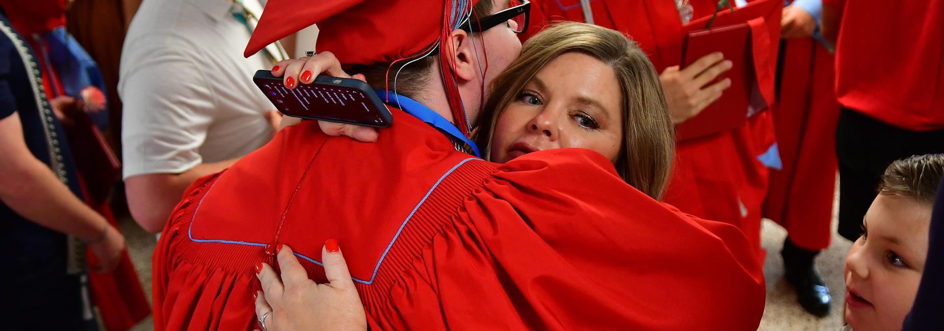 Mom hugging son that graduated.