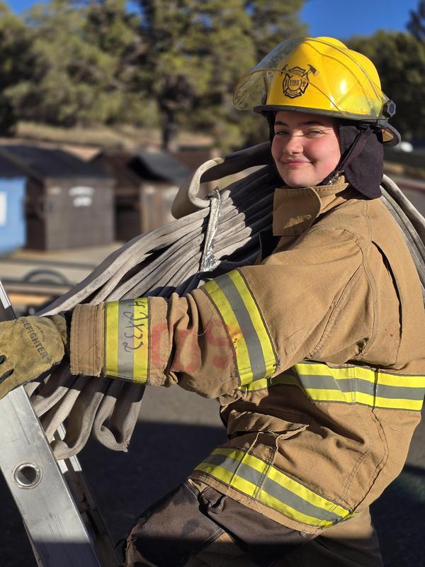 Woman in a fire fighter uniform sitting