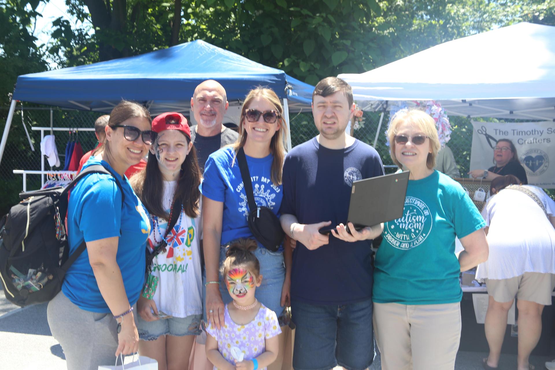 Family standing together at outside event.