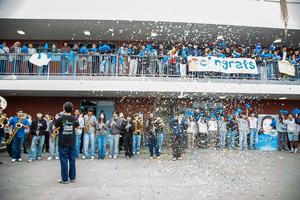 Walnut High School students cheer with poms while the band plays and confetti falls.