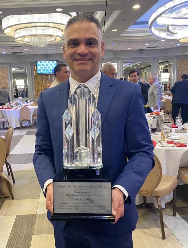 Coach Canela holding the Frank Tempone High School Coaching Excellence Award.