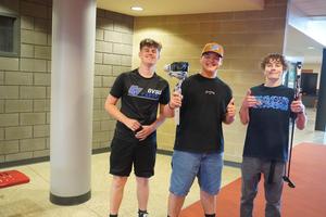 Three students use new cameras and equipment to work on a video production.