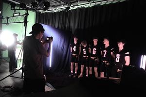 A group of players have their photo taken in the digital media studio.