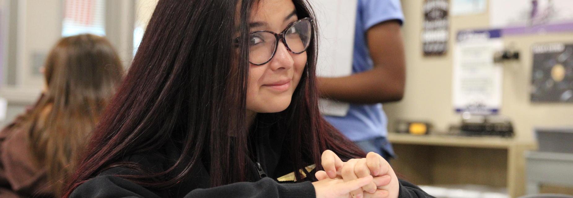 Student sitting in class looking at camera.