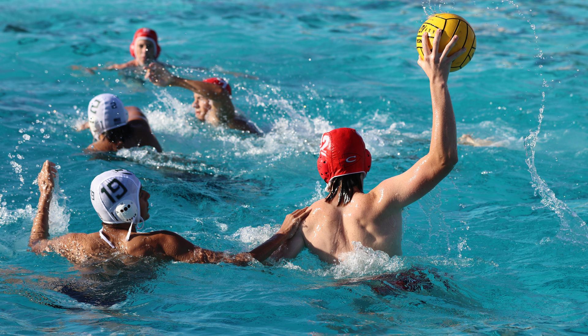 boys water polo players in action against hoover