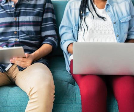 Two students working next to each other on laptops