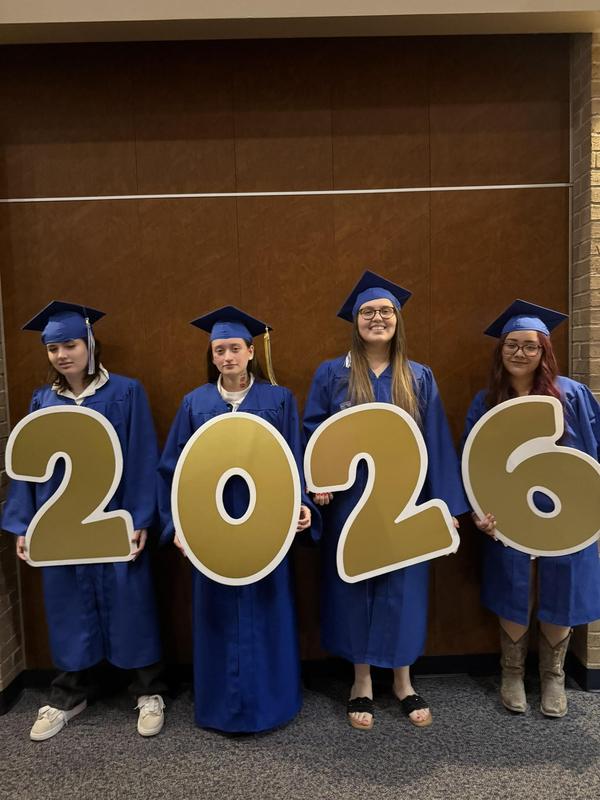 2026 Reese Education Center graduates posting with large 2026 signs