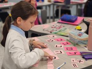 A fourth grade girl works to form her word as quickly as possible.