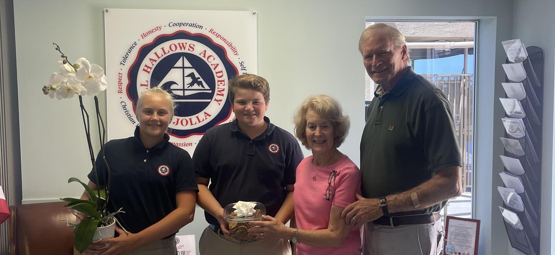 Family from parish poses with two Student Council members