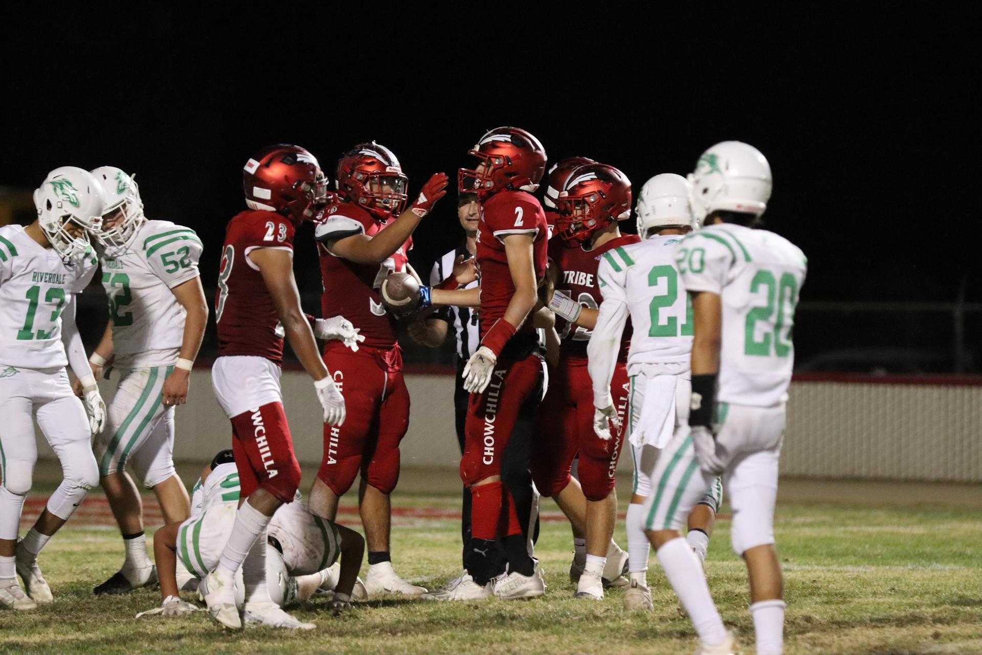varsity football players in action against Riverdale