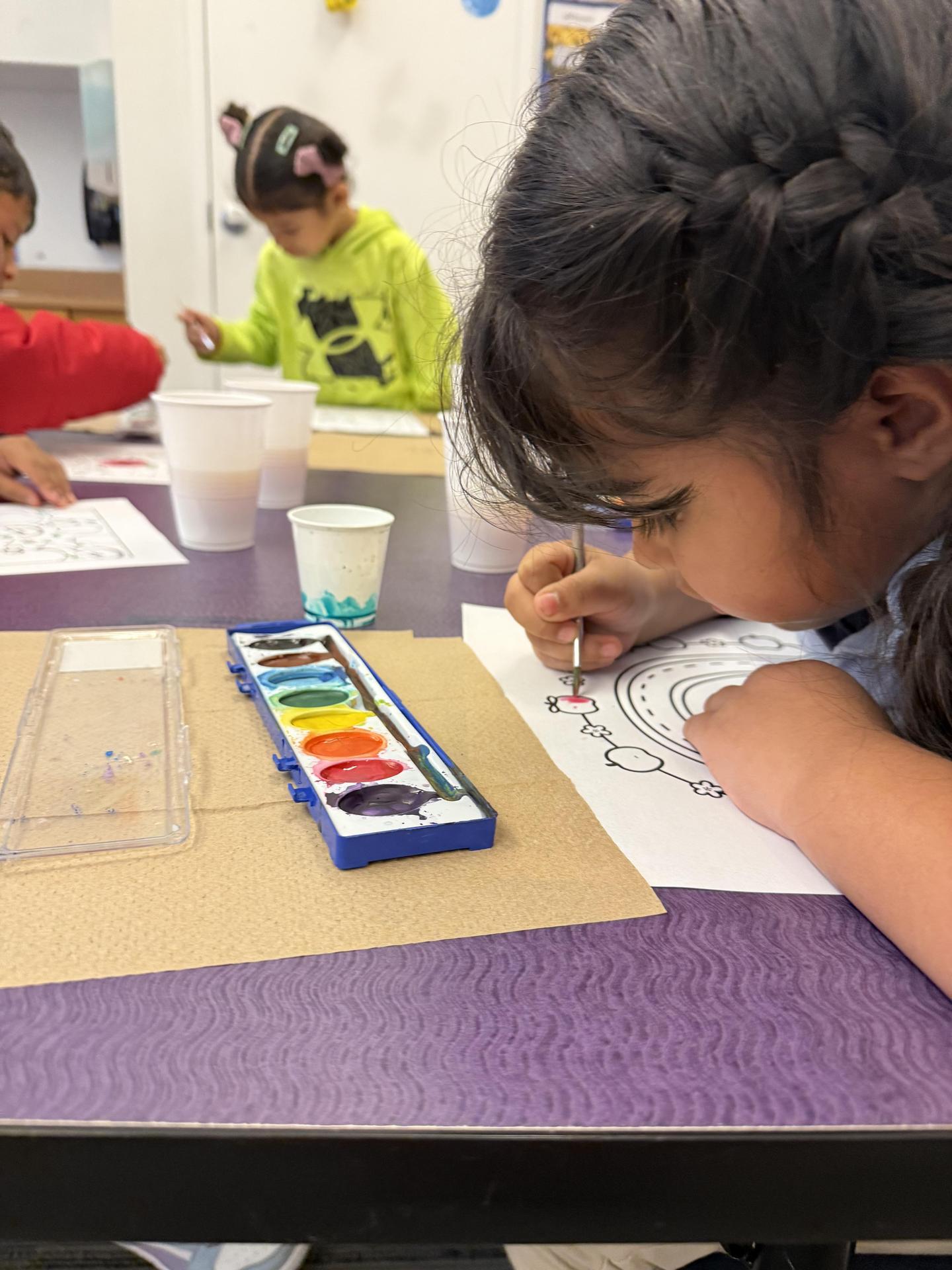 Student painint on a piece of paper