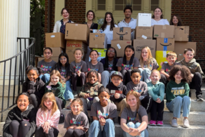Students smile with RMHC staff outside the building.