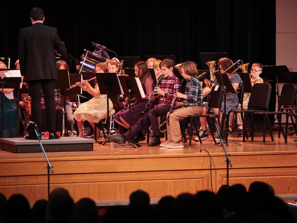 Elementary band students playing instruments on stage.