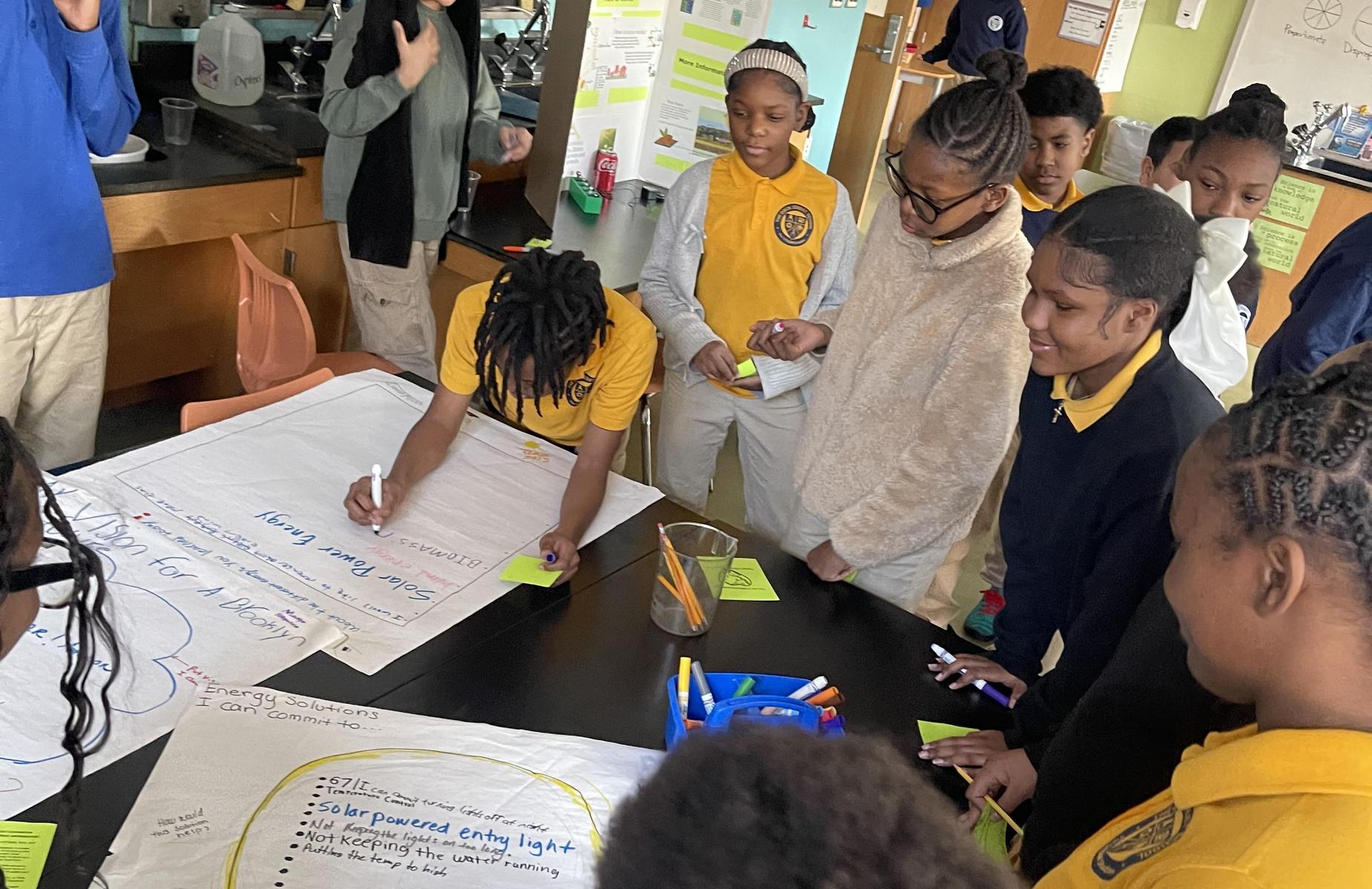 Students collaborating on a science project at a classroom table.