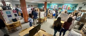 Smiling students stand with school projects