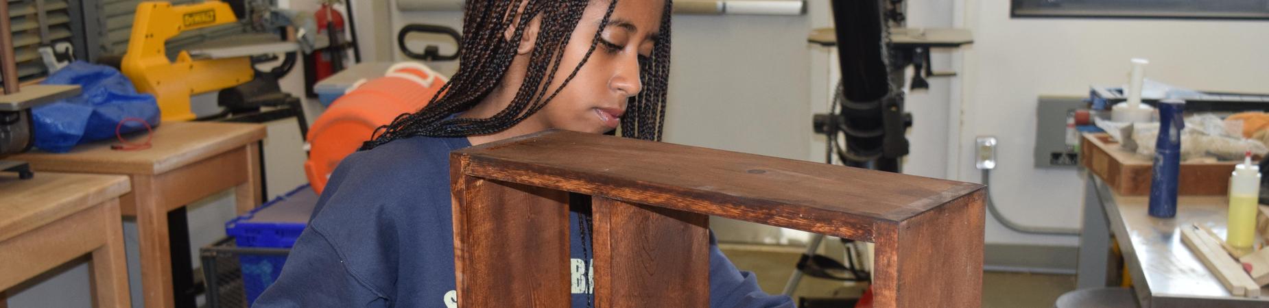 Student working with wood in woodshop;