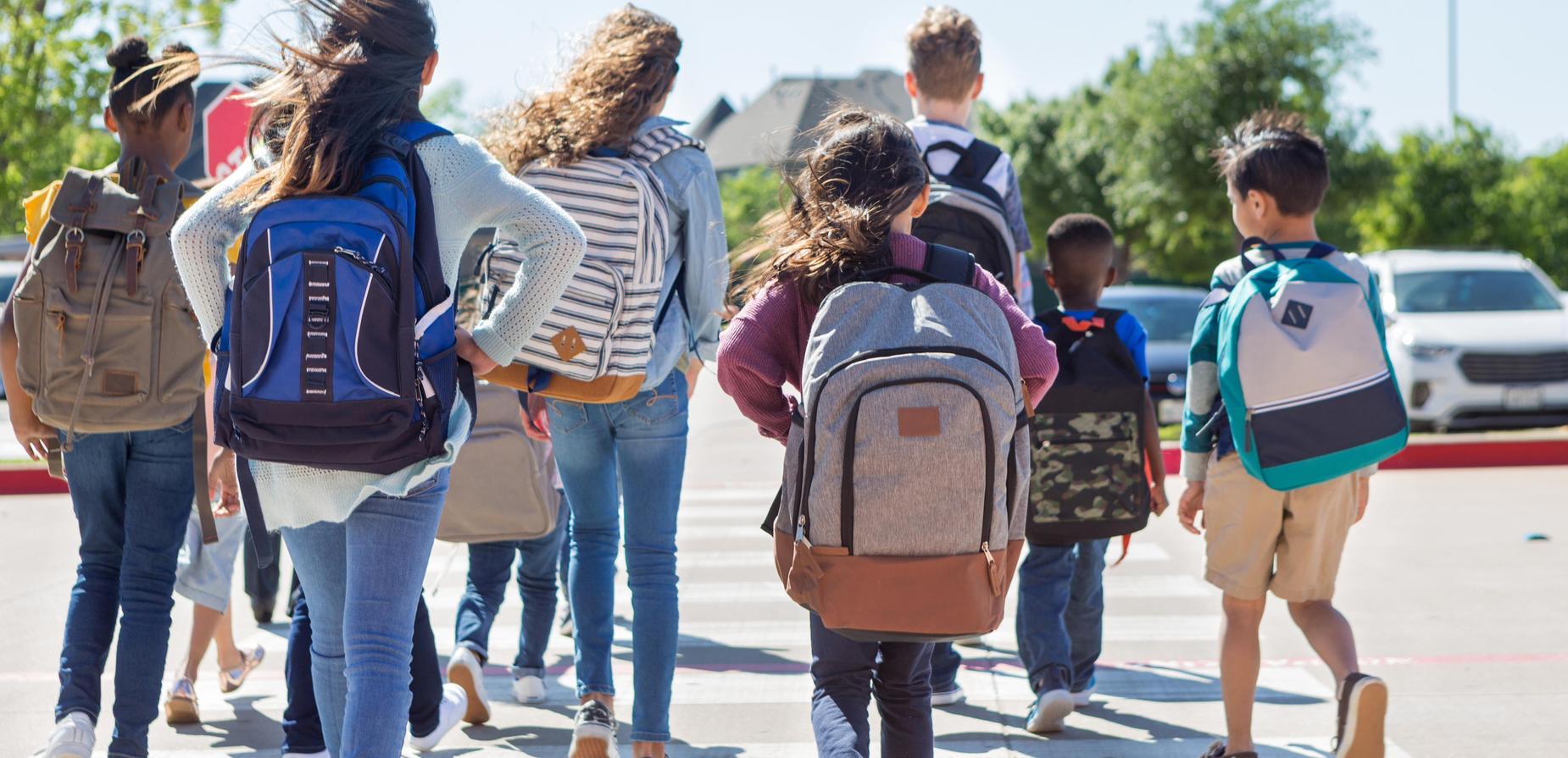 students walking wearing backpacks