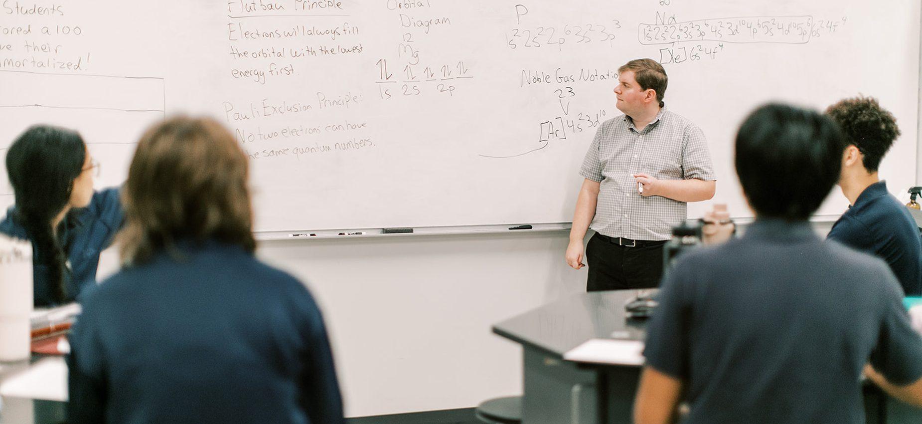 A teacher leads a lesson at the whiteboard