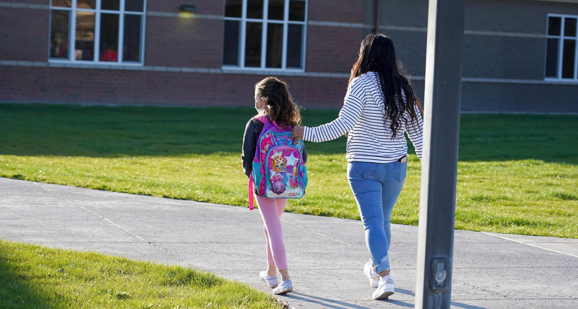 Mom and daughter walking to school.