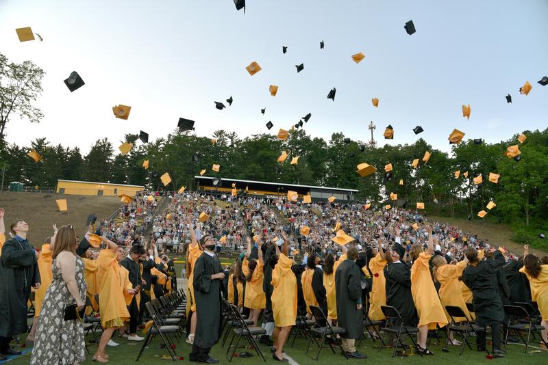 students at graduation throwing their caps in the air